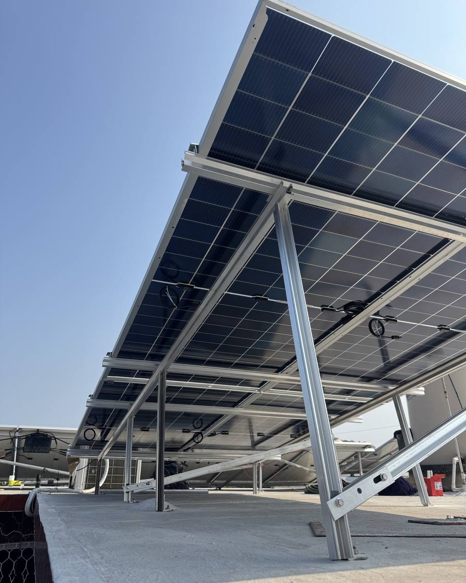 Estructura de aluminio elevada que sostiene paneles solares, vista desde abajo