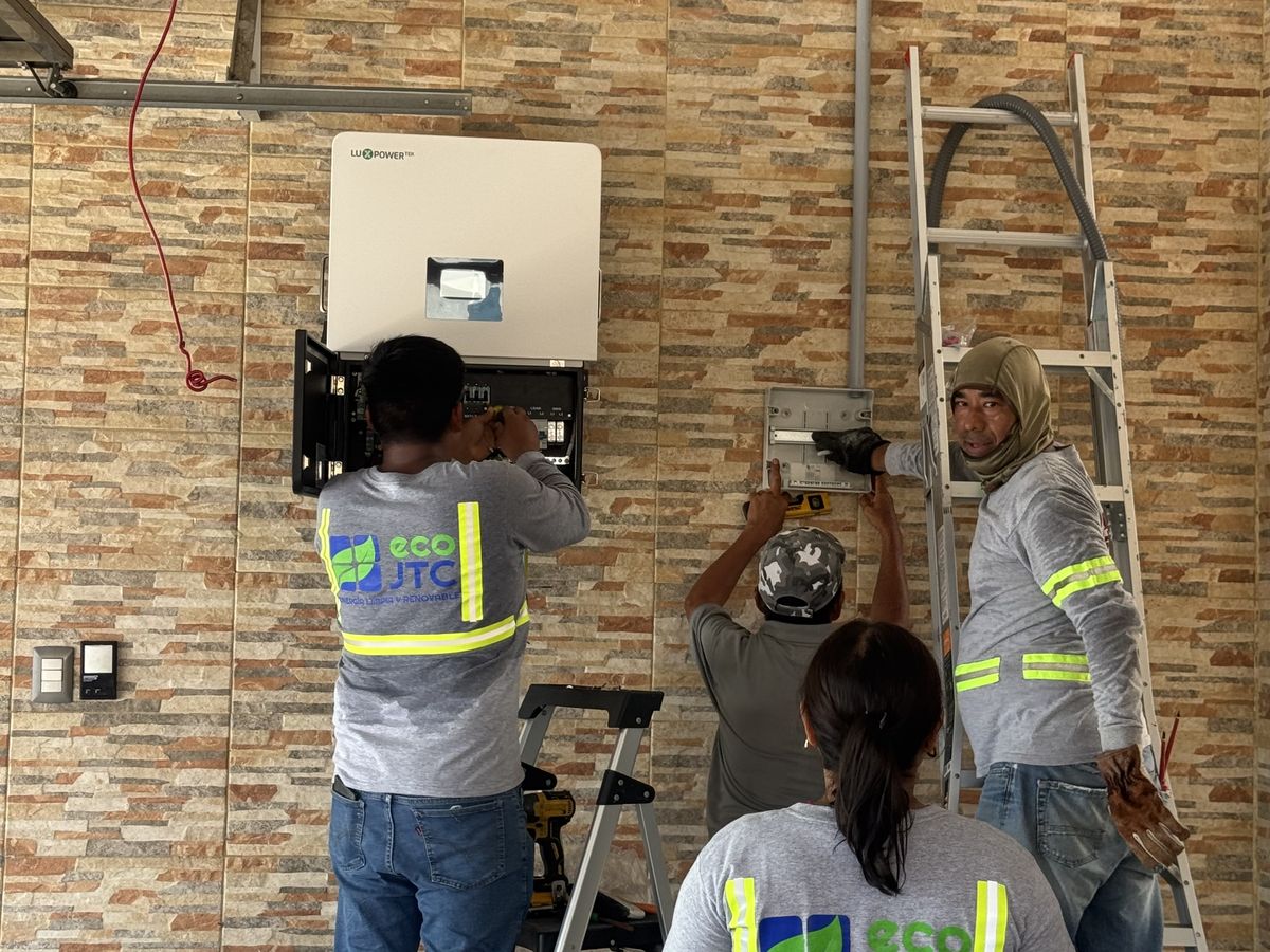 Cuadrilla de ECO JTC con uniforme instalando el inversor de un sistema solar