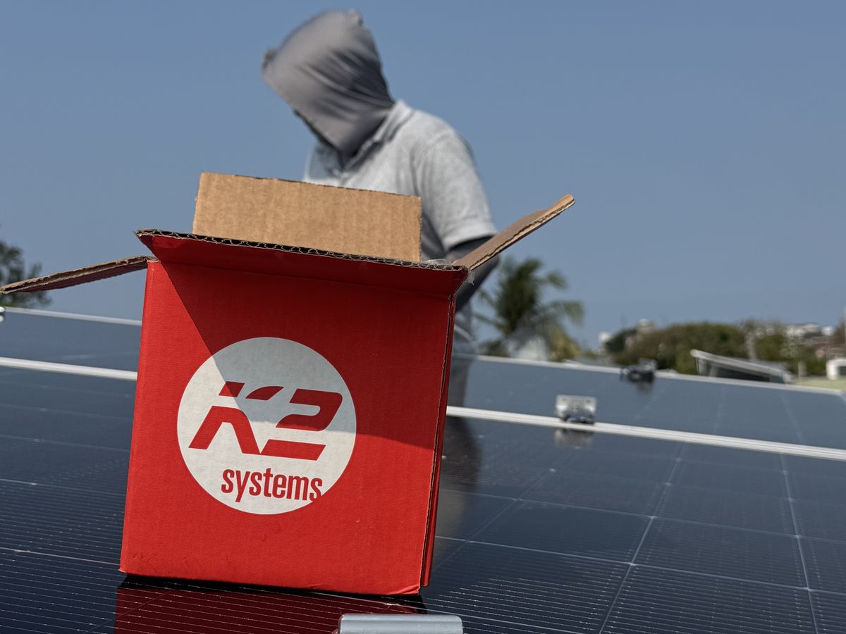 Caja de estructura K2 Systems junto a paneles solares durante una instalación