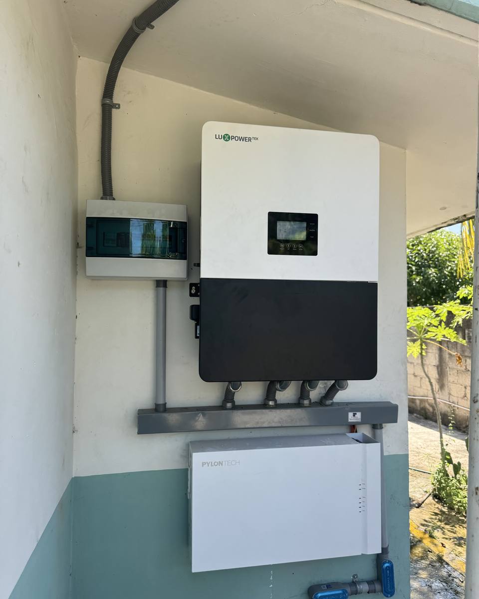 Inversor híbrido con batería instalado en la pared de una casa