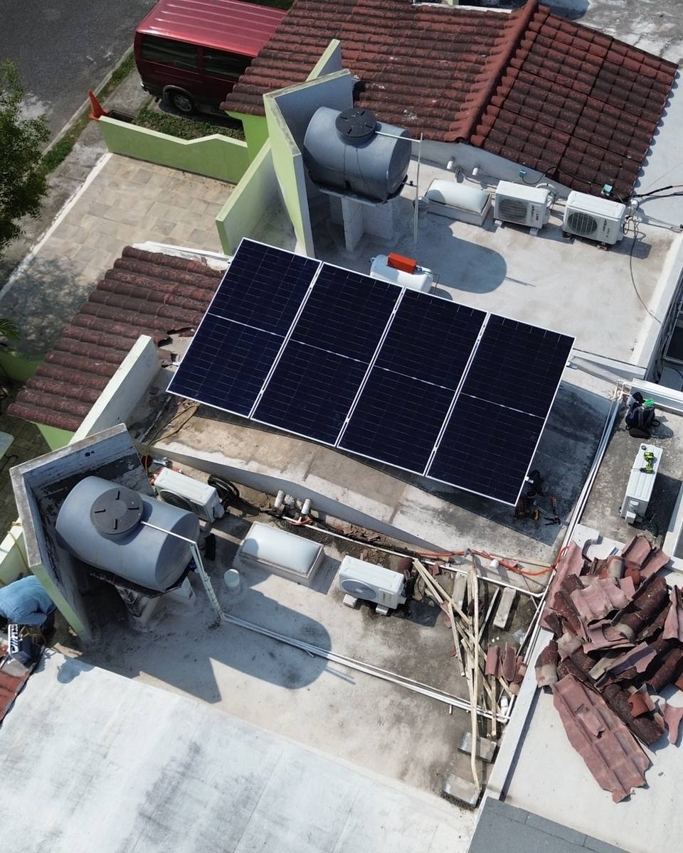 Arreglo de paneles solares en la azotea de una casa, visto desde dron